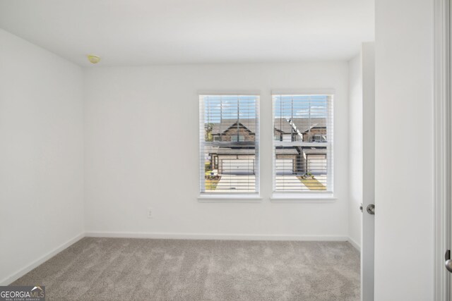 carpeted spare room with baseboards