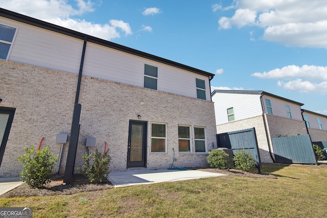 back of house featuring a lawn, fence, and a patio