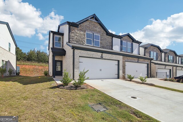 view of property with stone siding, driveway, a front lawn, and an attached garage