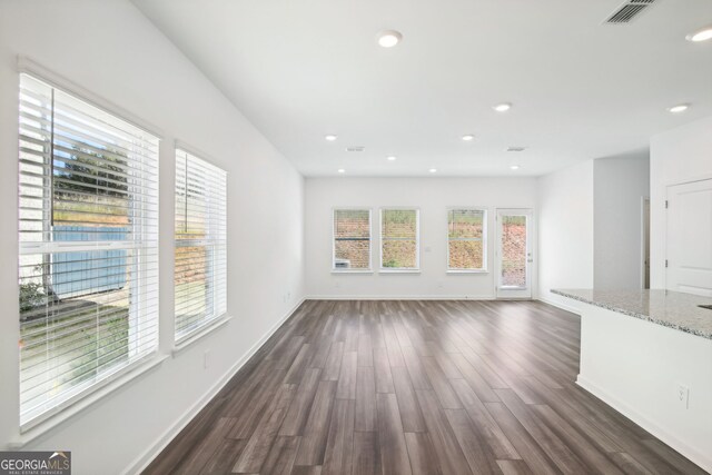 unfurnished living room with baseboards, visible vents, recessed lighting, and dark wood finished floors