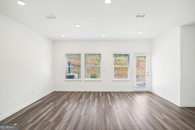 unfurnished room with baseboards, visible vents, recessed lighting, and dark wood finished floors