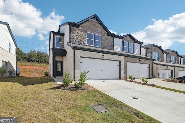 330 White Tail Rd, Stockbridge, GA 30253 - townhome / multi-family property featuring a front lawn, stone siding, an attached garage, and concrete driveway