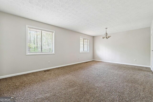 1360 Cypress Ridge Cir, Stone Mountain, GA 30083 - unfurnished room featuring baseboards, a textured ceiling, carpet, and an inviting chandelier