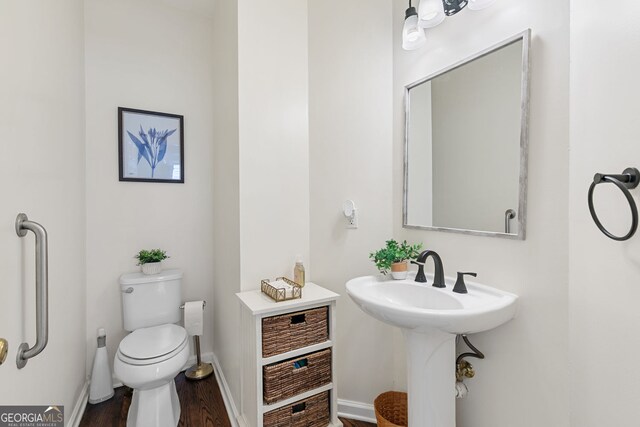 bathroom featuring toilet, baseboards, and wood finished floors