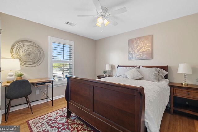bedroom featuring light wood-type flooring, a ceiling fan, baseboards, and visible vents