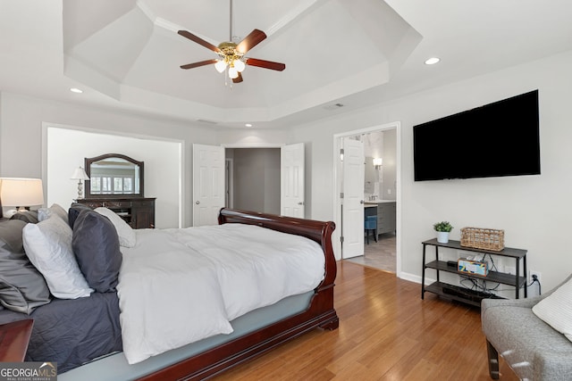bedroom featuring a raised ceiling, visible vents, light wood-style flooring, and recessed lighting