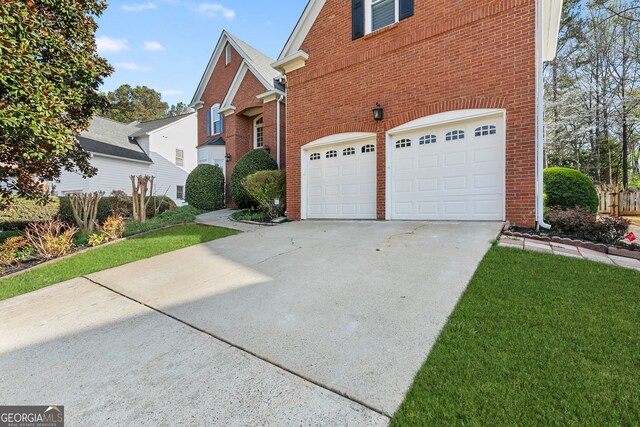 view of side of home featuring an attached garage, brick siding, and concrete driveway