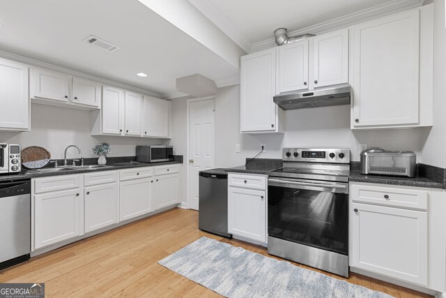 kitchen featuring light wood-style flooring, under cabinet range hood, visible vents, white cabinets, and appliances with stainless steel finishes