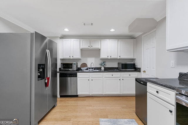 kitchen with visible vents, white cabinetry, a sink, and appliances with stainless steel finishes
