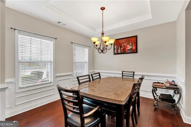 95 Summerlyn Dr, Hiram, GA 30141 - dining room featuring a chandelier, a wainscoted wall, a raised ceiling, dark wood-style flooring, and a decorative wall