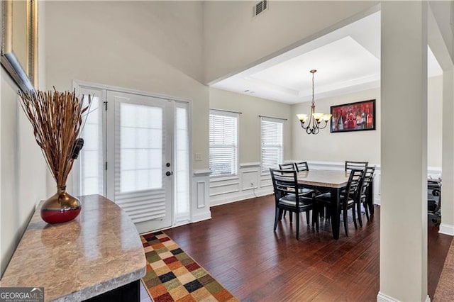 95 Summerlyn Dr, Hiram, GA 30141 - dining area with dark wood-style floors, a chandelier, a tray ceiling, a wainscoted wall, and a decorative wall