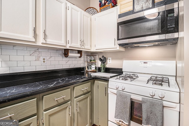 kitchen featuring stainless steel microwave, decorative backsplash, dark countertops, white cabinets, and white range with gas cooktop