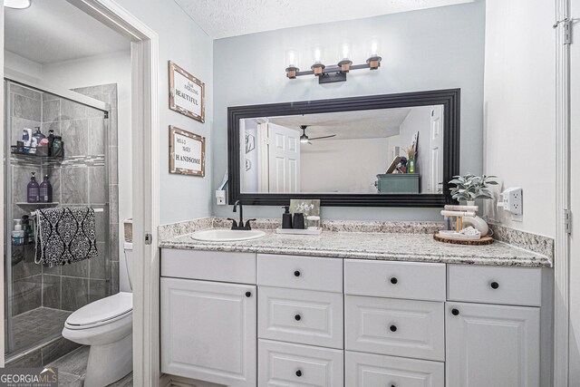 90 Chimney Rise Ct, Stockbridge, GA 30281 - bathroom with a stall shower, toilet, a ceiling fan, vanity, and a textured ceiling