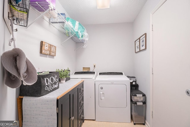 laundry area featuring independent washer and dryer, cabinet space, light floors, and a textured ceiling