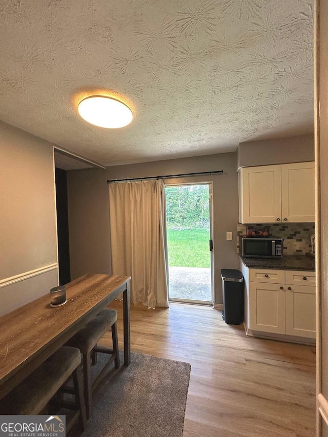 2900 Haddon Dr, Rex, GA 30273 - unfurnished dining area with light wood-style flooring and a textured ceiling