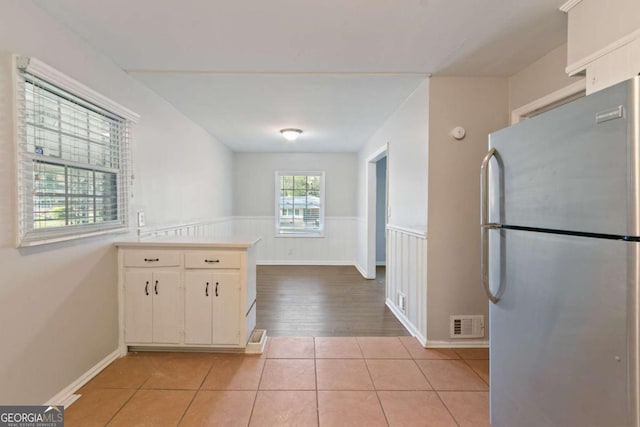 121 Hillsdale Dr SE, Atlanta, GA 30315 - kitchen with freestanding refrigerator, a peninsula, light countertops, a wainscoted wall, and light tile patterned floors