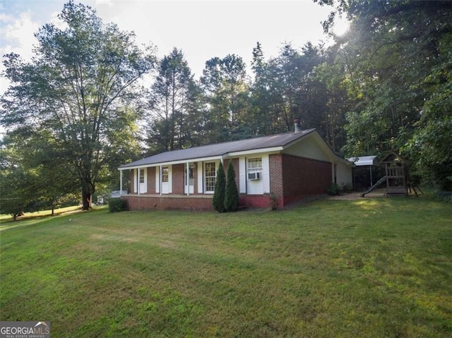view of front of property featuring covered porch, cooling unit, brick siding, and a front yard