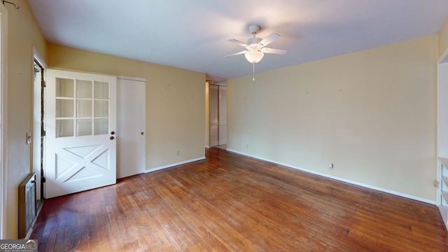 empty room featuring baseboards, a ceiling fan, and wood finished floors