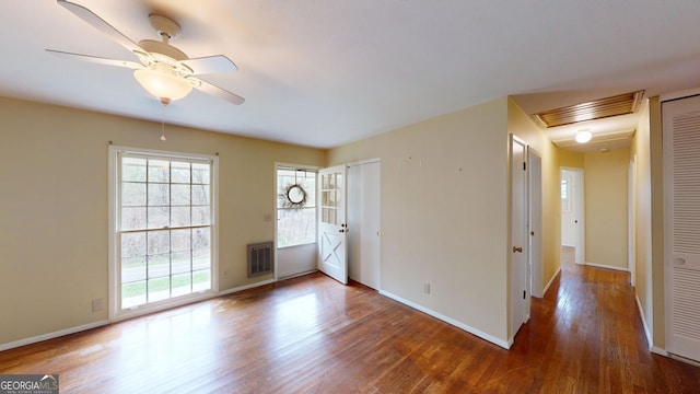 empty room featuring baseboards, ceiling fan, wood finished floors, and visible vents