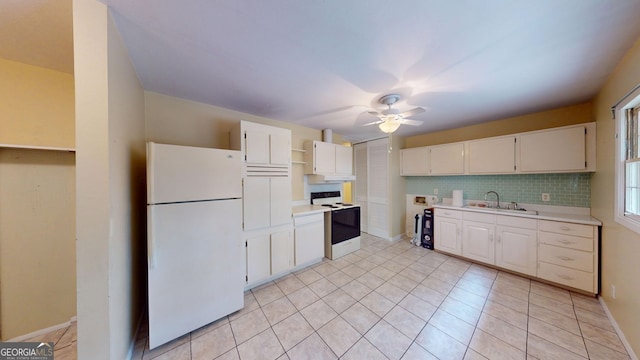 kitchen with freestanding refrigerator, open shelves, light countertops, electric range oven, and a sink