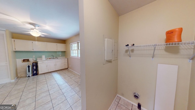 washroom featuring ceiling fan, cabinet space, a sink, hookup for a washing machine, and light tile patterned flooring