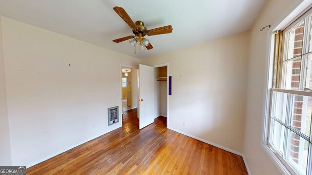 empty room with baseboards, light wood finished floors, ceiling fan, and visible vents