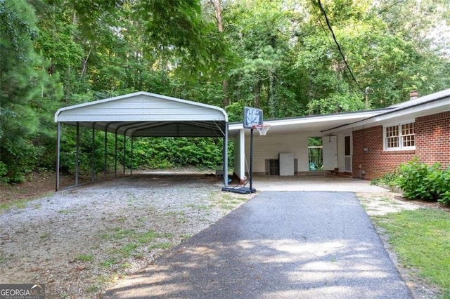 view of vehicle parking with aphalt driveway and a carport