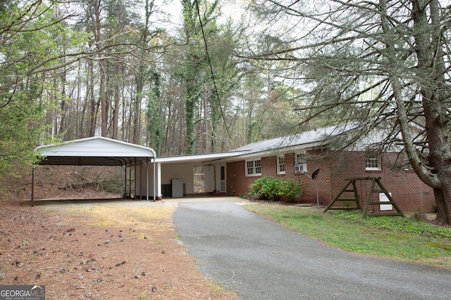 single story home with brick siding, aphalt driveway, and a carport