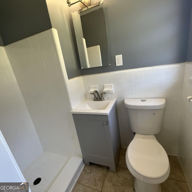 2502 Miriam Ln, Decatur, GA 30032 - full bathroom featuring vanity, toilet, a shower stall, a wainscoted wall, and tile patterned flooring