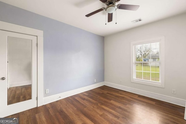 unfurnished room featuring a ceiling fan, visible vents, baseboards, and wood finished floors