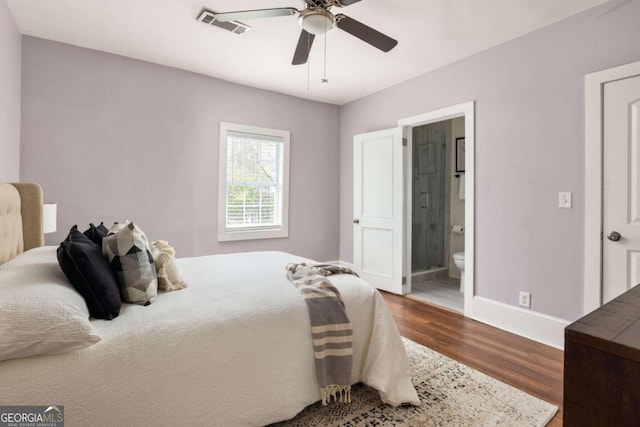 bedroom with connected bathroom, wood finished floors, baseboards, visible vents, and ceiling fan