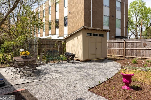 view of patio / terrace featuring fence, an outdoor structure, and a shed