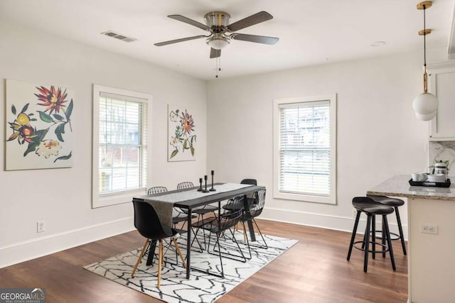 dining room featuring baseboards, visible vents, wood finished floors, and ceiling fan