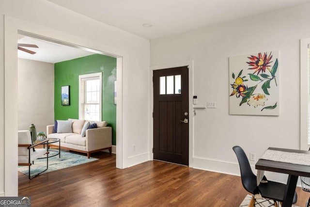 entryway featuring dark wood-type flooring, ceiling fan, and baseboards