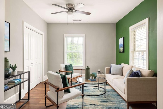 living room featuring visible vents, ceiling fan, and wood finished floors
