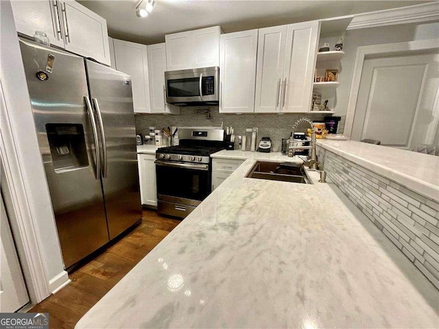 kitchen with open shelves, stainless steel appliances, backsplash, a sink, and white cabinets