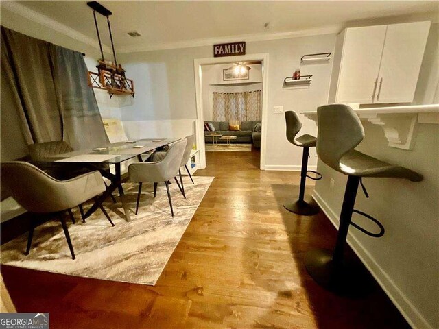dining area featuring baseboards, crown molding, and wood finished floors