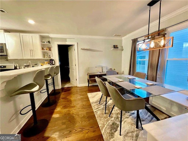 dining area with baseboards, ornamental molding, and dark wood-type flooring