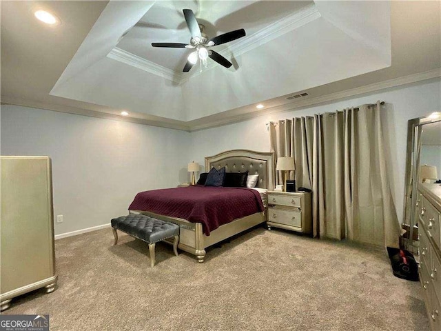 bedroom with a tray ceiling, carpet flooring, and ornamental molding
