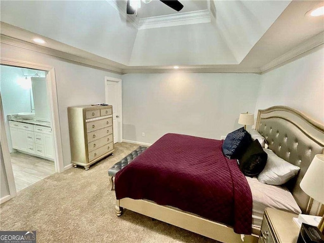 bedroom featuring a tray ceiling, light colored carpet, ornamental molding, baseboards, and ensuite bath