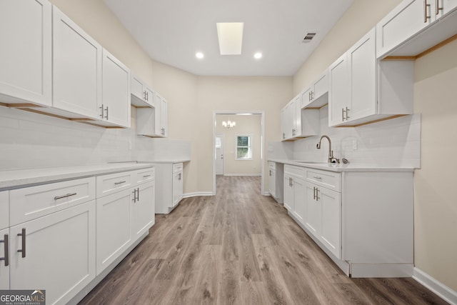 556 James P Brawley Dr NW, Atlanta, GA 30318 - kitchen with decorative backsplash, light wood finished floors, recessed lighting, light countertops, and white cabinets