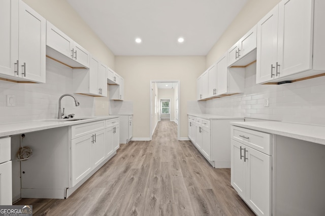 556 James P Brawley Dr NW, Atlanta, GA 30318 - kitchen with backsplash, light wood-type flooring, recessed lighting, light countertops, and white cabinetry