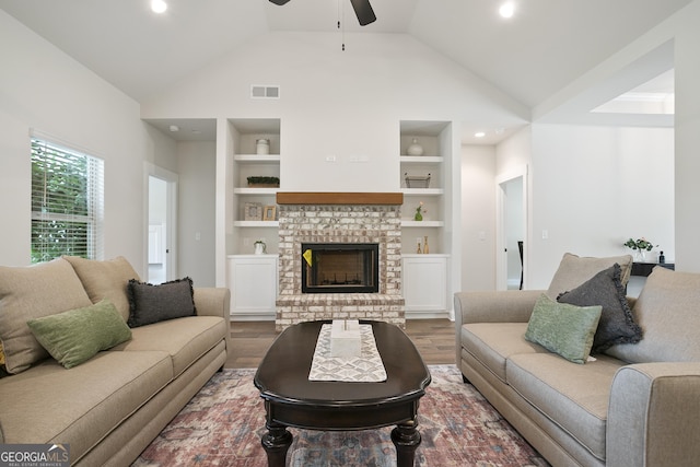 8 Hardin Ct Lot 16, Newnan, GA 30263 - living area featuring a ceiling fan, built in shelves, wood finished floors, vaulted ceiling, and a brick fireplace