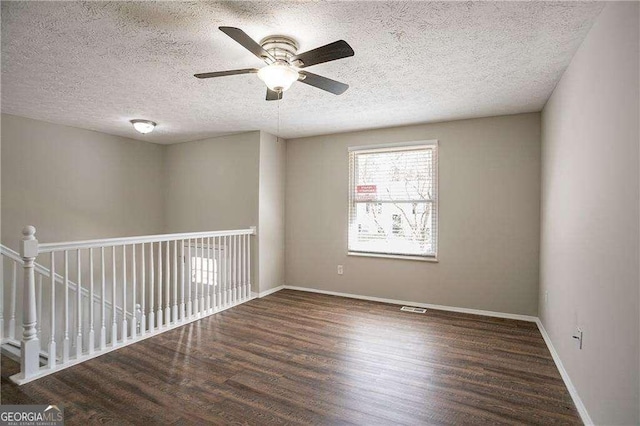 unfurnished room featuring a ceiling fan, wood finished floors, a textured ceiling, baseboards, and visible vents