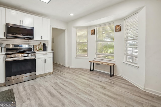 hall with light wood finished floors, baseboards, and ornamental molding