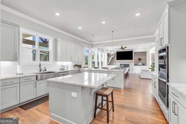 kitchen featuring ceiling fan, backsplash, a sink, a peninsula, and open floor plan