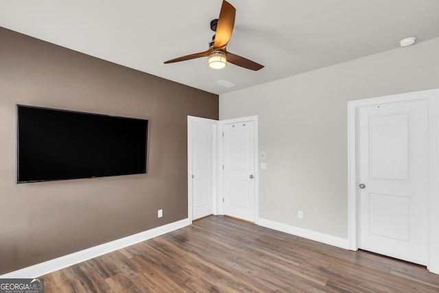 unfurnished bedroom featuring baseboards, ceiling fan, and wood finished floors