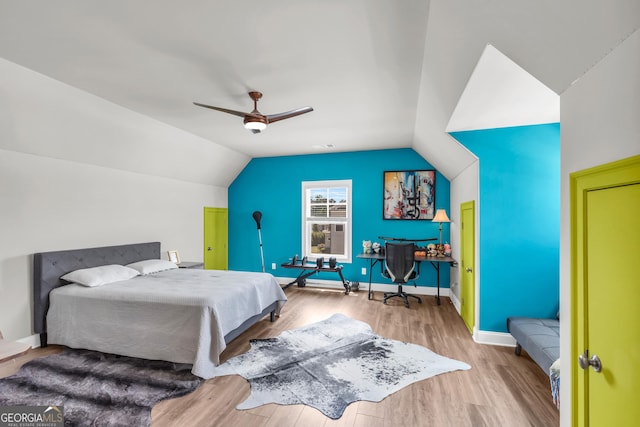 bedroom with baseboards, ceiling fan, wood finished floors, and lofted ceiling