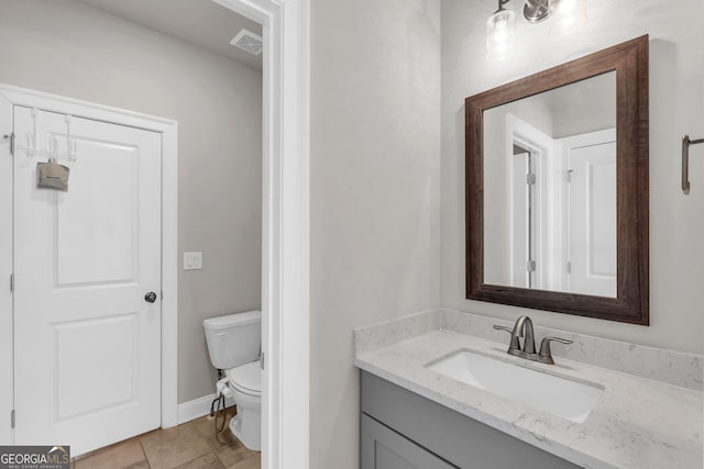bathroom with visible vents, vanity, toilet, baseboards, and tile patterned floors