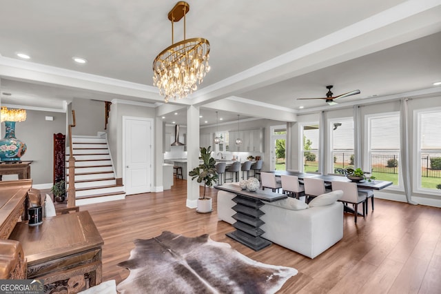 living room featuring stairway, ornamental molding, and wood finished floors